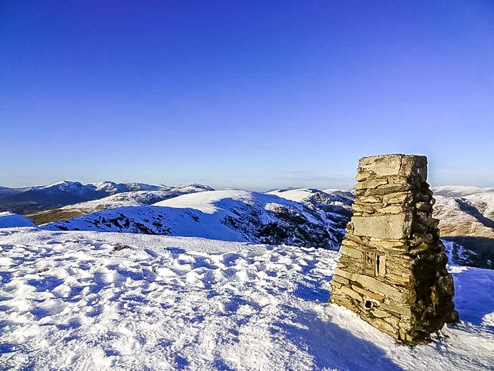 the summit of the old man of coniston in winter snow